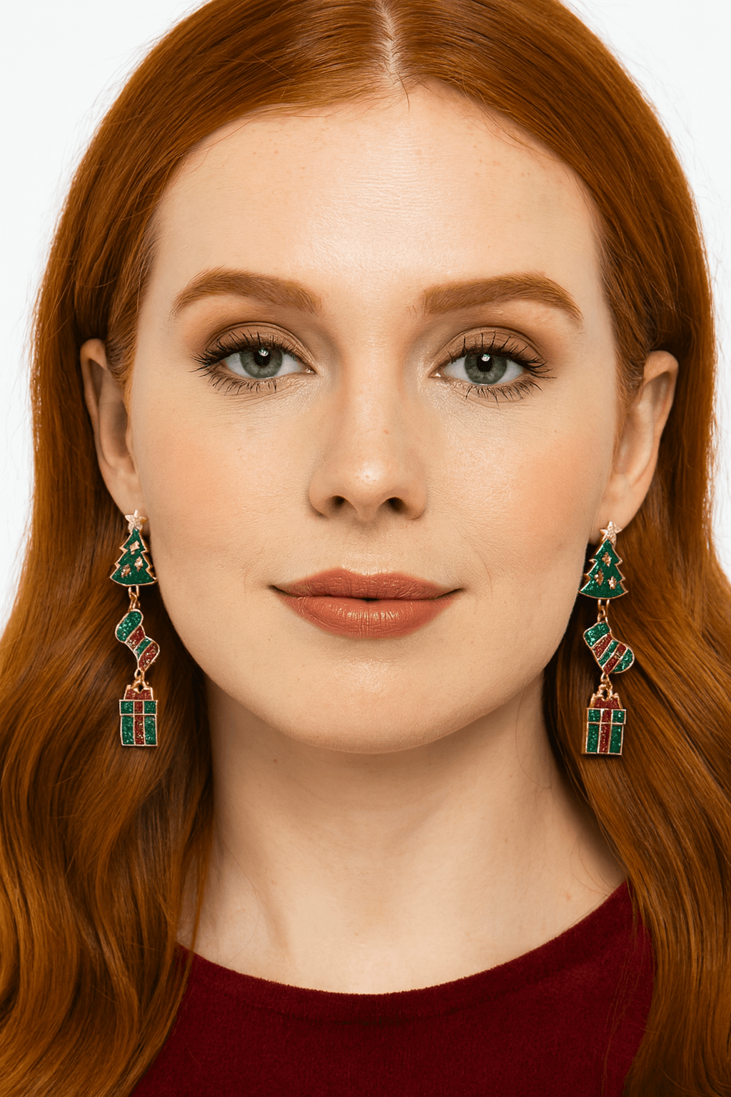 Woman wearing holiday dangle earrings featuring a glitter Christmas tree, striped stocking, and gift box charms in red and green.
