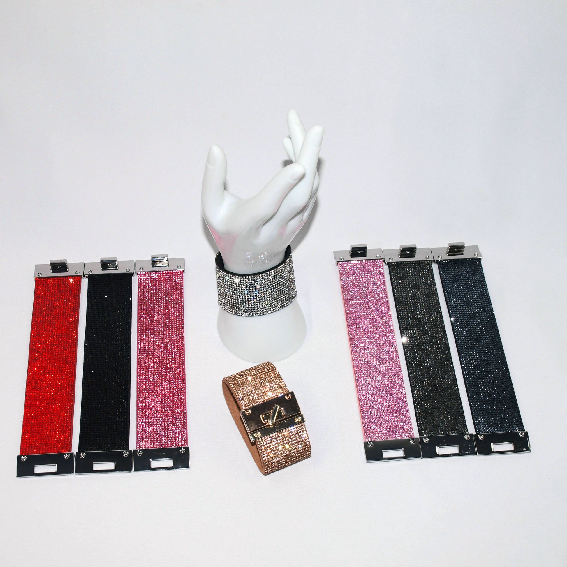 Wide rhinestone cuff bracelets in red, black, hot pink, rose gold, crystal, pink, off black, and ink displayed together
