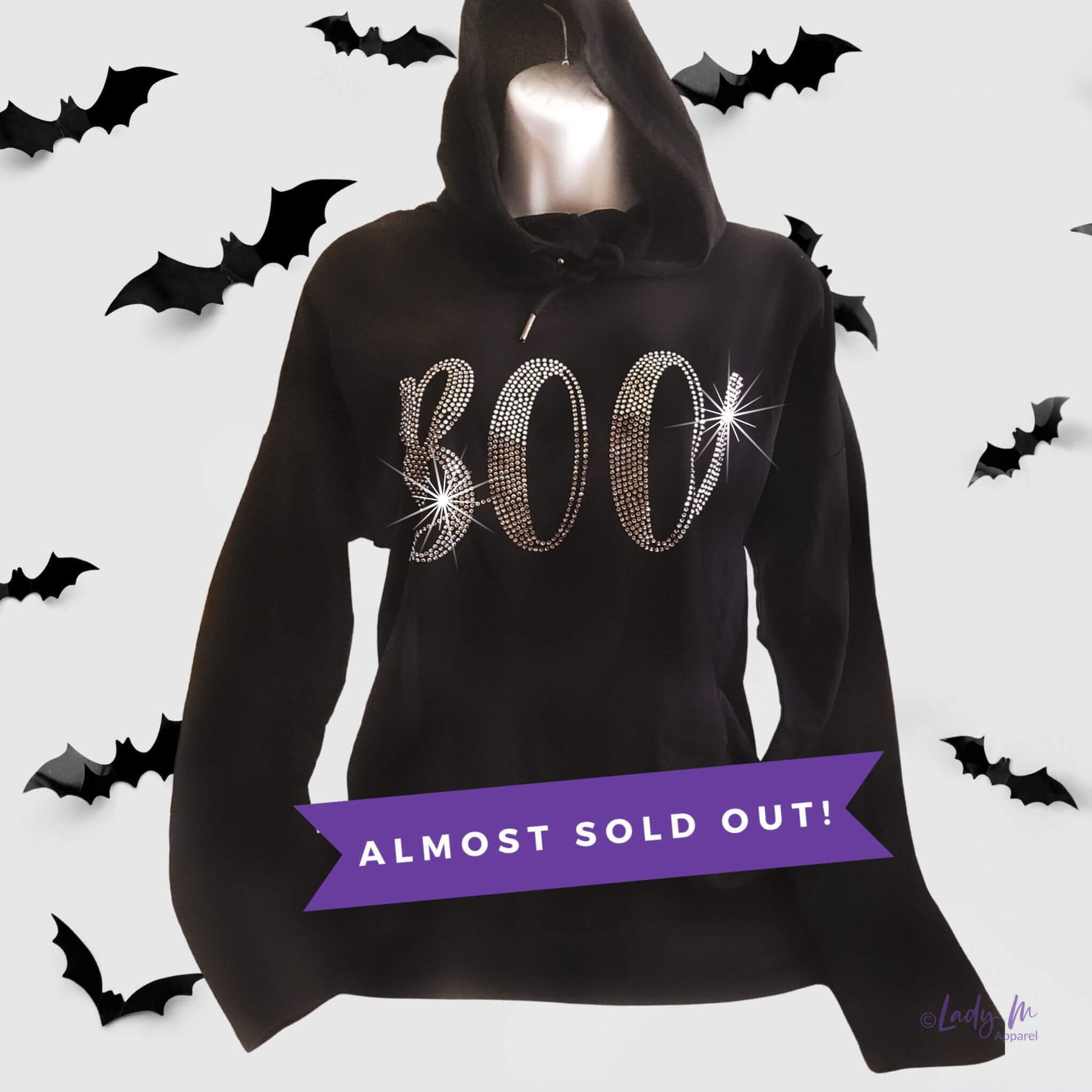 Women’s black lightweight Halloween rhinestone tunic hoodie with sparkling “BOO” design — festive bling top for spooky season, almost sold out.