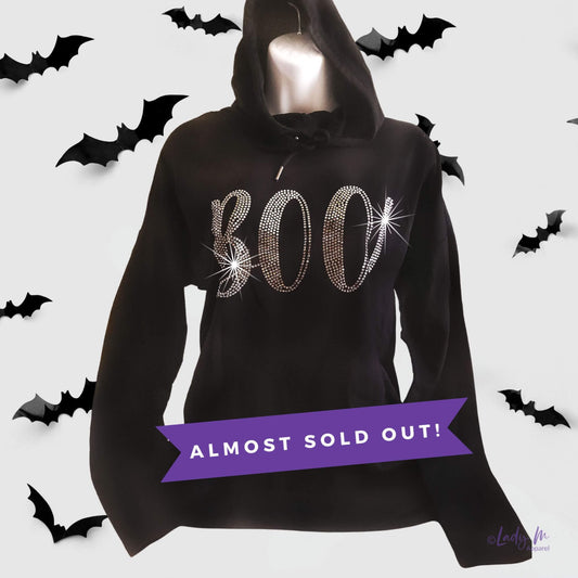 Women’s black lightweight Halloween rhinestone tunic hoodie with sparkling “BOO” design — festive bling top for spooky season, almost sold out.